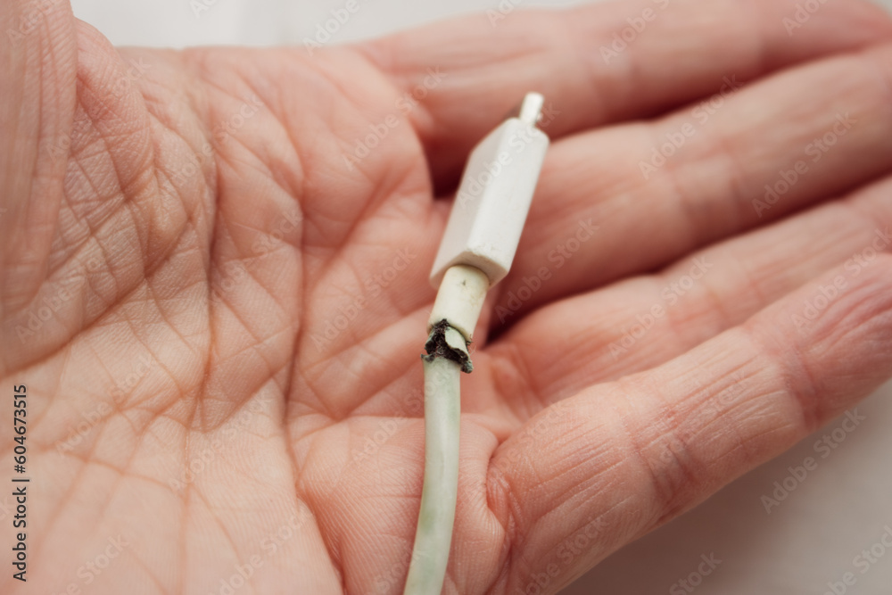 Foto de Broken electric plug in hand. Broken power cord in woman hand
