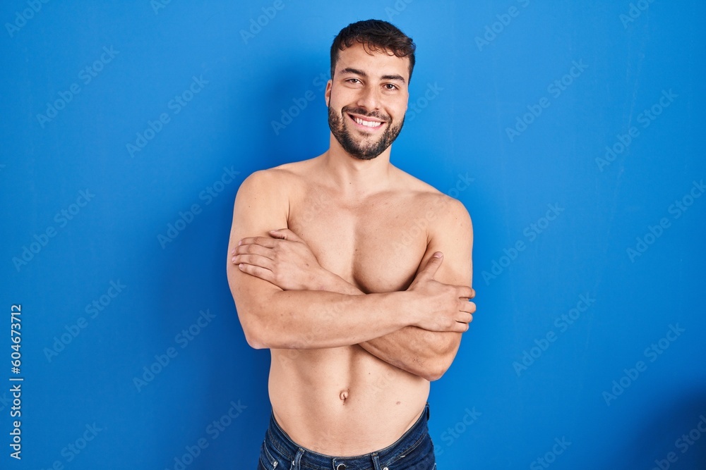 Handsome hispanic man standing shirtless happy face smiling with crossed arms looking at the camera. positive person.