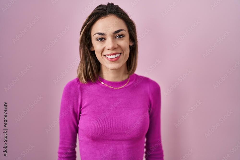 Hispanic woman standing over pink background with a happy and cool smile on face. lucky person. Hispanic woman standing over pink background with a happy and cool smile on face. lucky person.