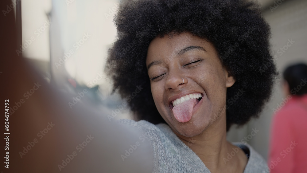 African american woman making selfie by camera doing with tongue out of mouth at street African american woman making selfie by camera doing with tongue out of mouth at street