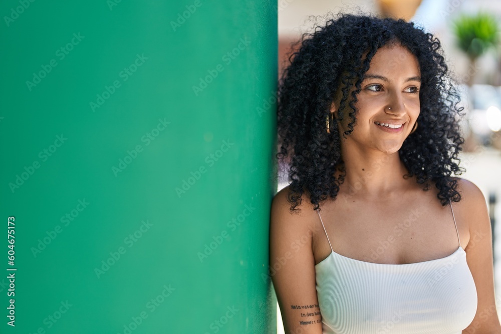 Fototapeta premium Young hispanic woman smiling confident looking to the side at street