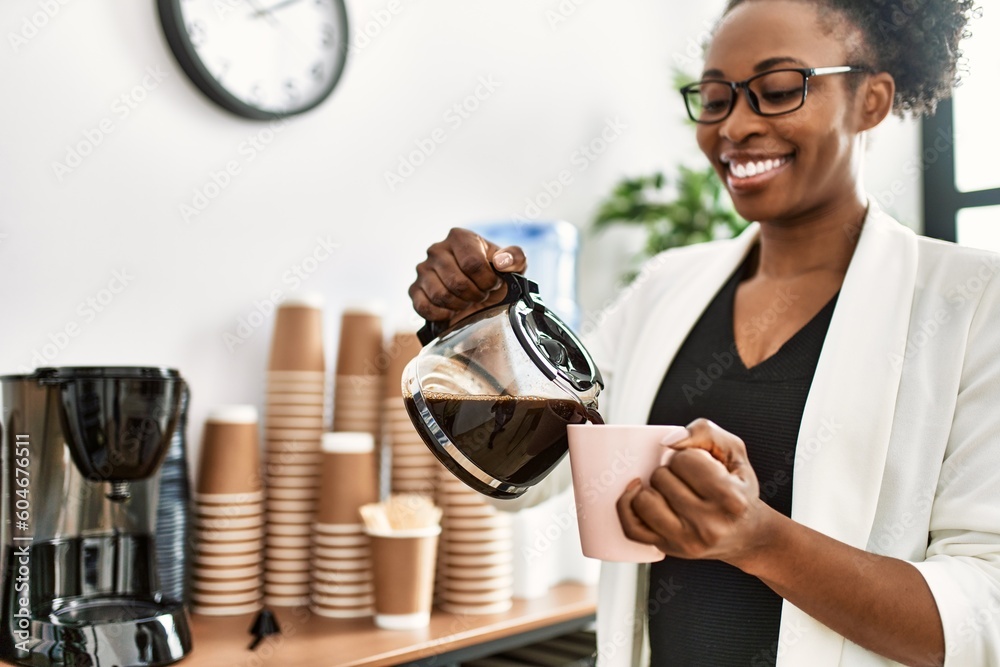 African american woman business worker pouring coffee on cup at office