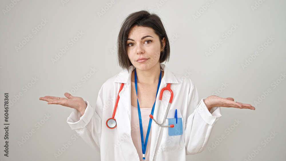 Young caucasian woman doctor standing with doubt expression with arms raised over isolated white background Young caucasian woman doctor standing with doubt expression with arms raised over isolated white background