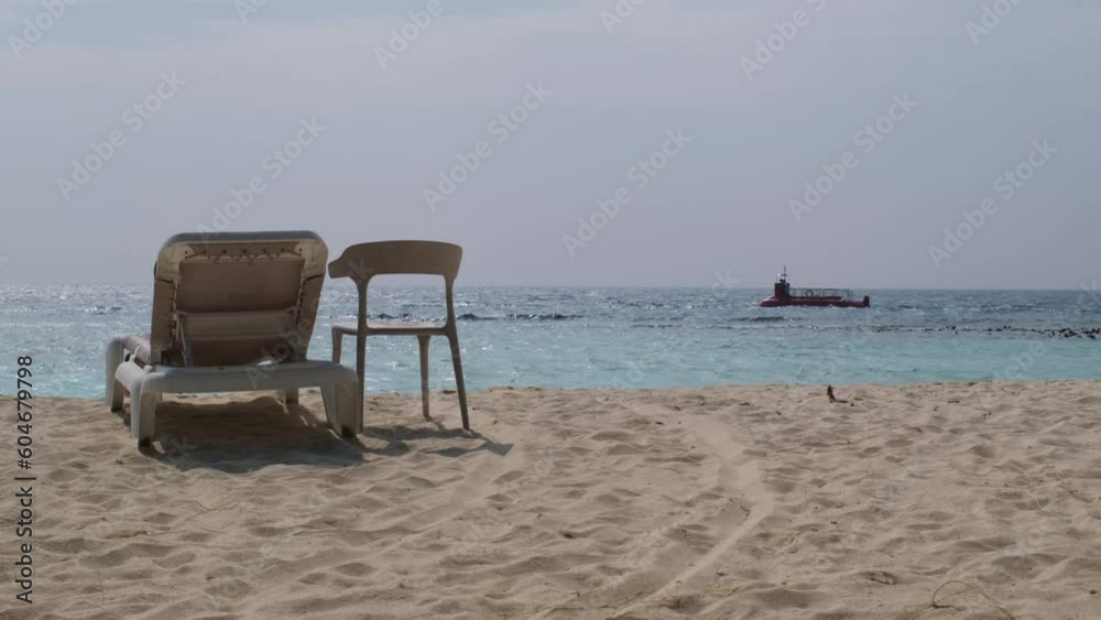 Empty sandy beach with sunbeds over boats in Indian ocean Empty sandy beach with sunbeds over boats in Indian ocean