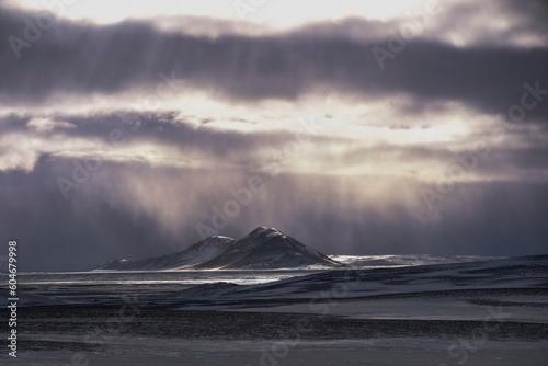 Sunlight through clouds in a snowstorm over a remote landscape, Iceland photo