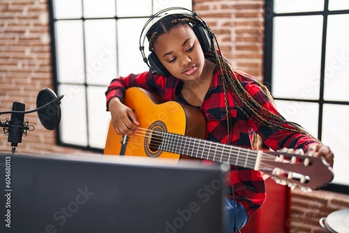 Canvas Print African american woman musician playing classical guitar at music studio