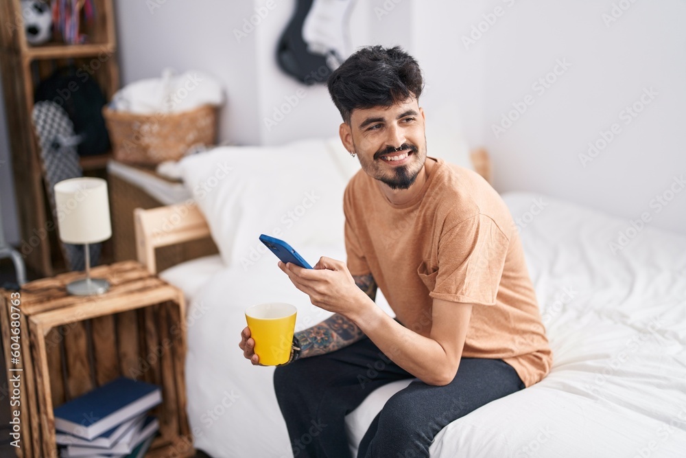 Young hispanic man using smartphone drinking coffee at bedroom Young hispanic man using smartphone drinking coffee at bedroom