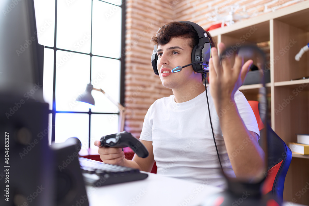 Non binary man streamer playing video game using joystick at gaming room Non binary man streamer playing video game using joystick at gaming room