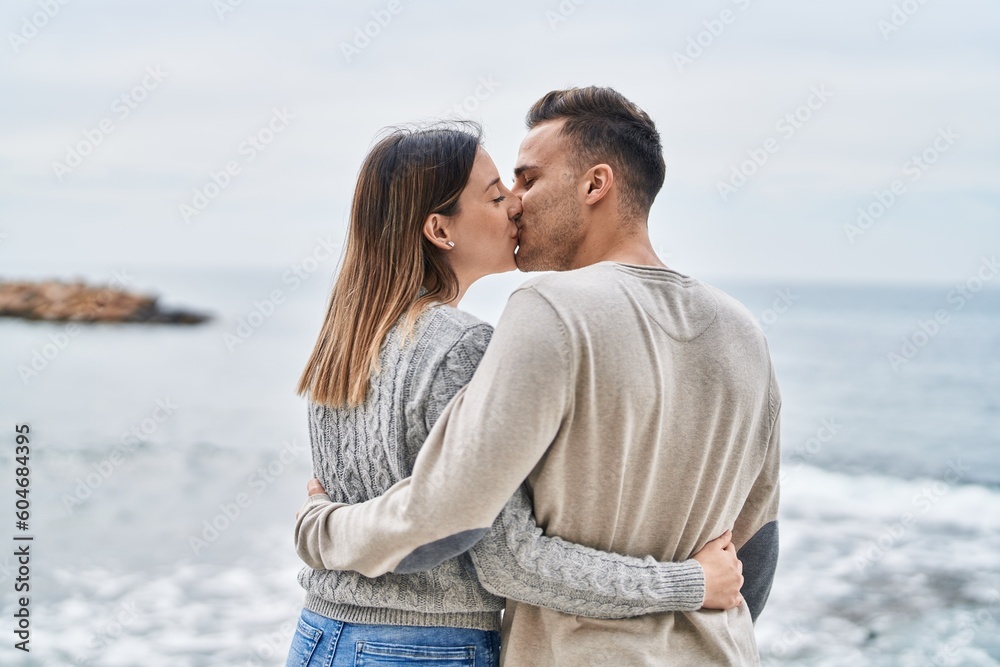 Man and woman couple hugging each other kissing at seaside Man and woman couple hugging each other kissing at seaside