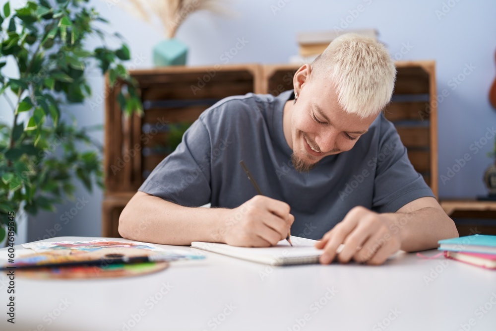 Young caucasian man smiling confident drawing on notebook at home Young caucasian man smiling confident drawing on notebook at home