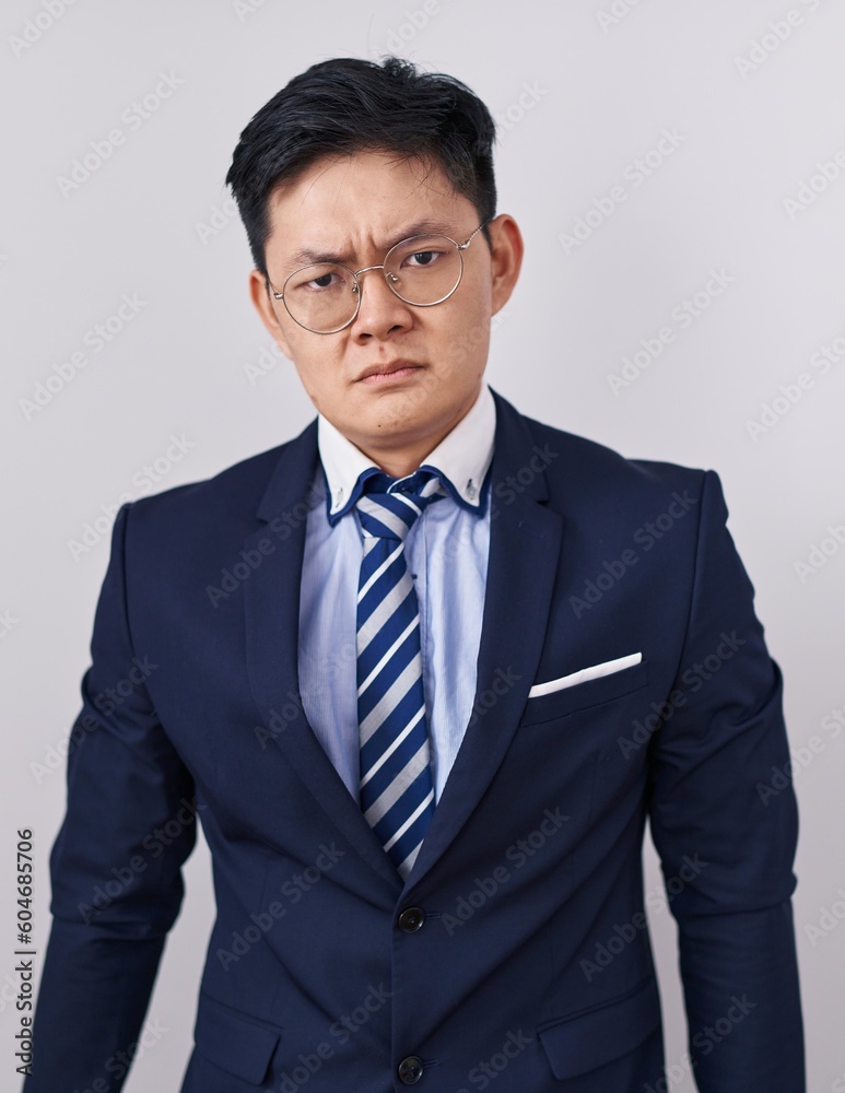 Young asian man wearing business suit and tie depressed and worry for distress, crying angry and afraid. sad expression.