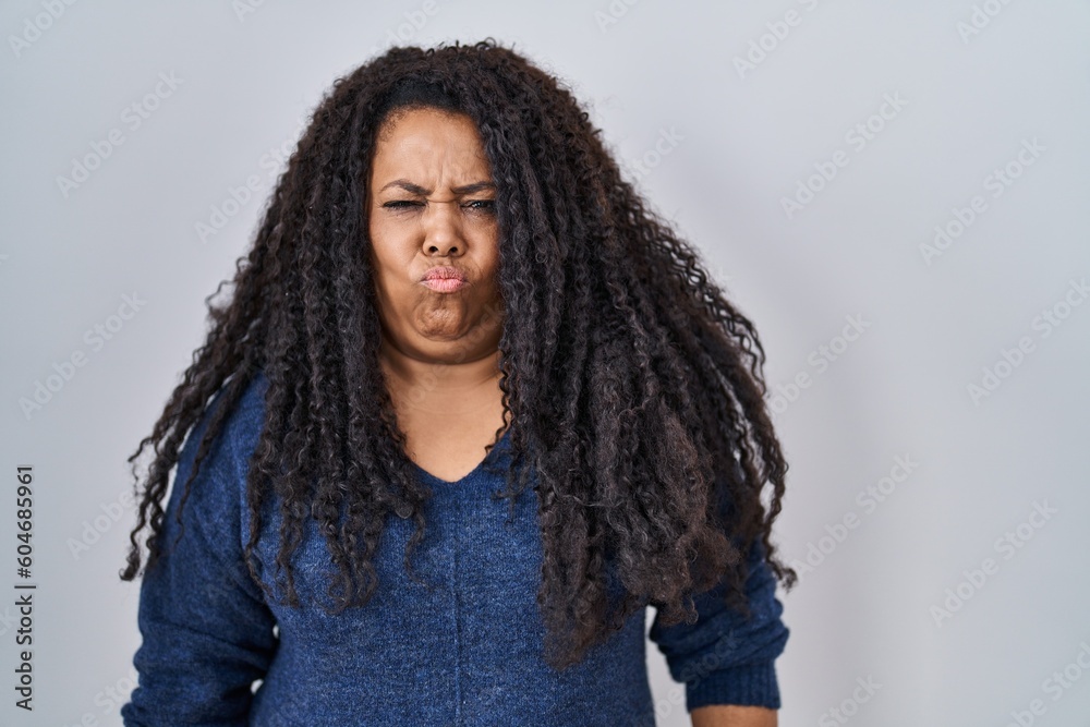 Plus size hispanic woman standing over white background depressed and worry for distress, crying angry and afraid. sad expression.