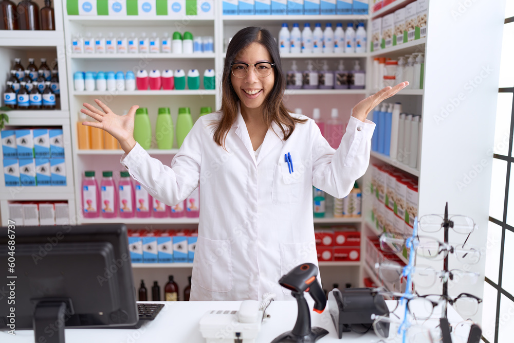 Middle age chinese woman working at pharmacy drugstore celebrating victory with happy smile and winner expression with raised hands