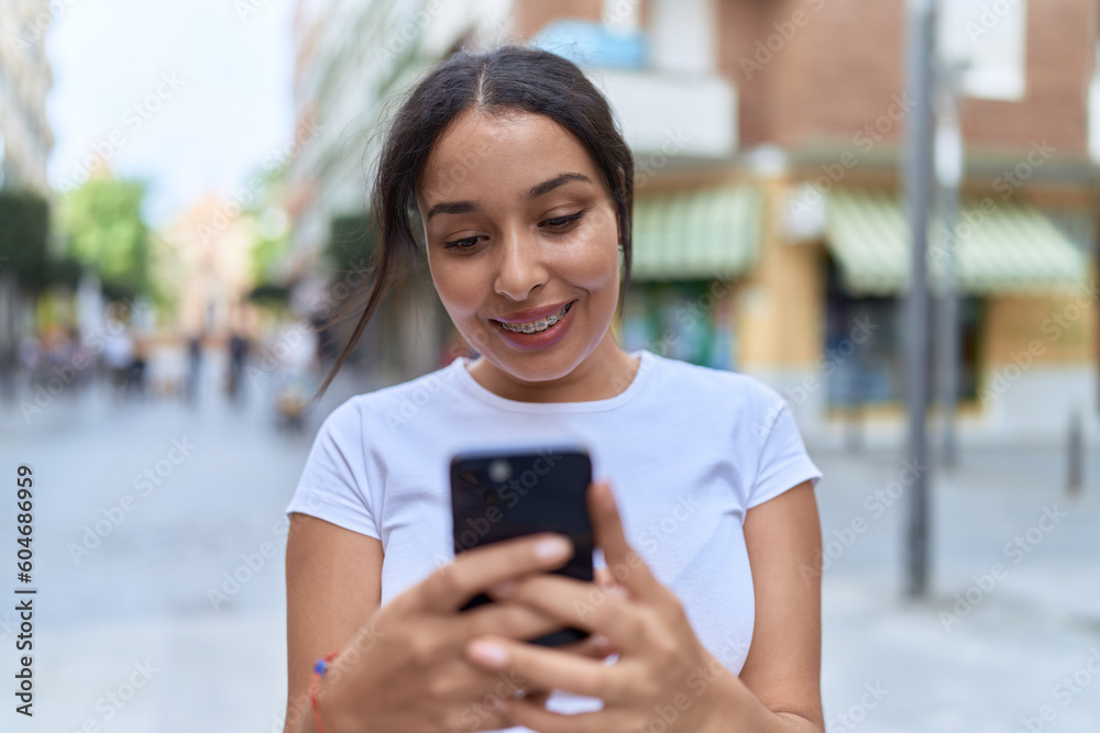 Young arab woman smiling confident using smartphone at street