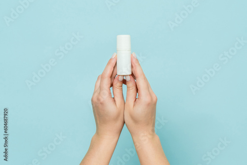 Bottle of eye drops (nasal spray) in woman's hand. Copy space