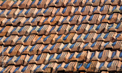 On the roof of the house is an old red tile