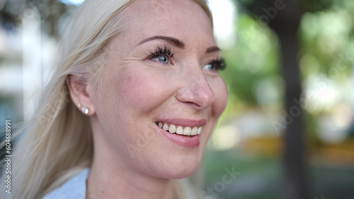 Young blonde woman smiling confident looking to the side at park