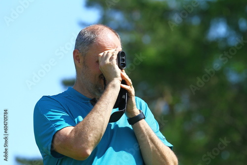 Man golfer with golf rangefinder