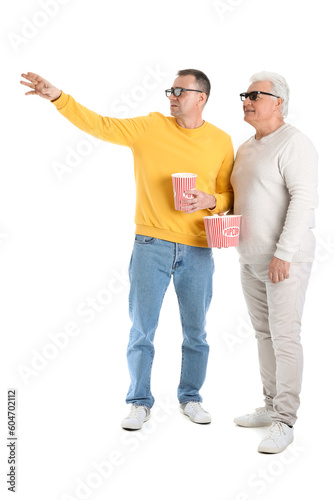 Mature brothers in 3D glasses with popcorn on white background
