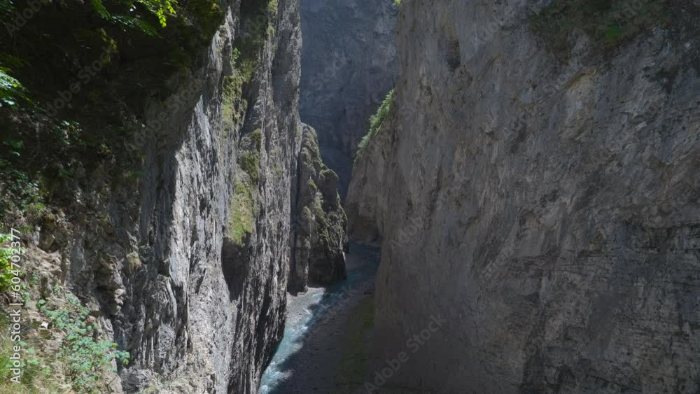 River between rocks of a narrow gorge. Stream of water is squeezed between the sides of the rocks. Linthschlucht, Linth Gorge, Linthal, Canton of Glarus, Switzerland River between rocks of a narrow gorge. Stream of water is squeezed between the sides of the rocks. Linthschlucht, Linth Gorge, Linthal, Canton of Glarus, Switzerland