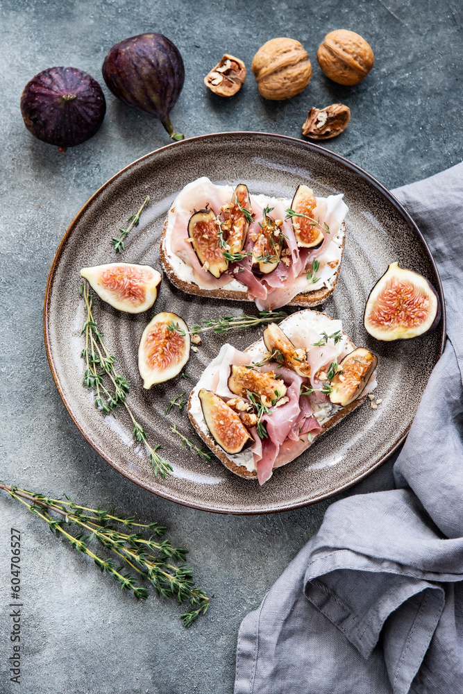 Toasts with cream cheese, figs and ham on the table Toasts with cream cheese, figs and ham on the table
