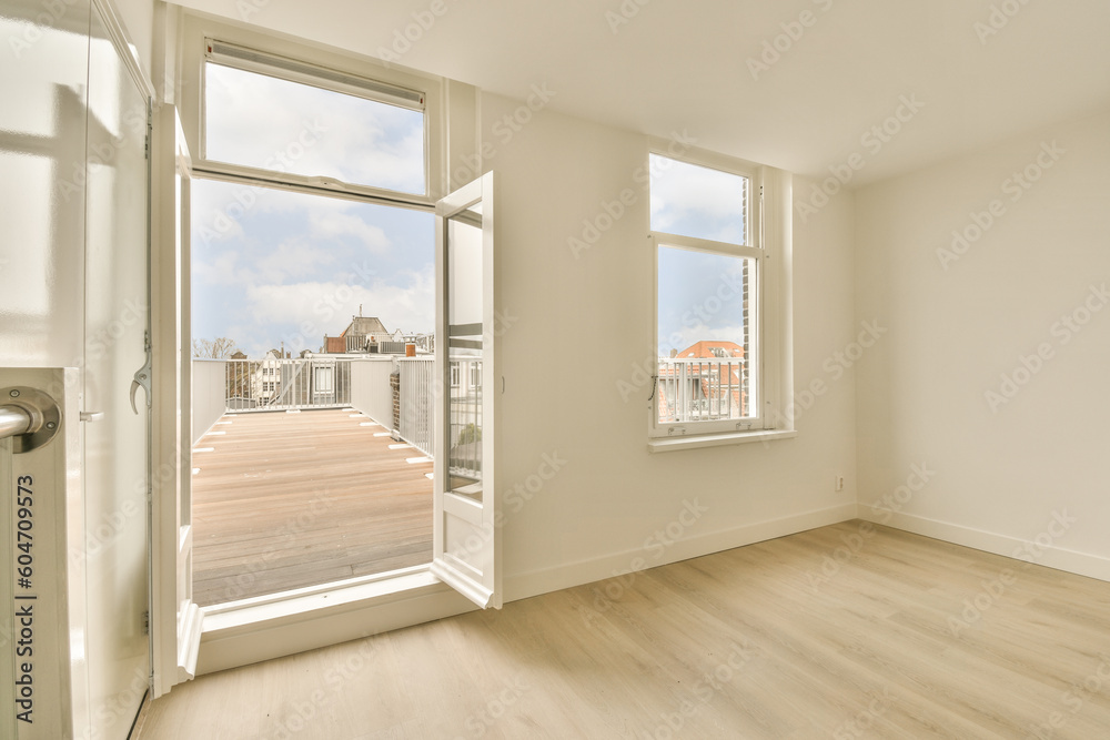 Fototapeta premium an empty room with wood floors and white walls, looking out onto the street from inside one of the rooms