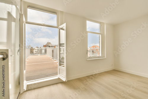 an empty room with wood floors and white walls  looking out onto the street from inside one of the rooms