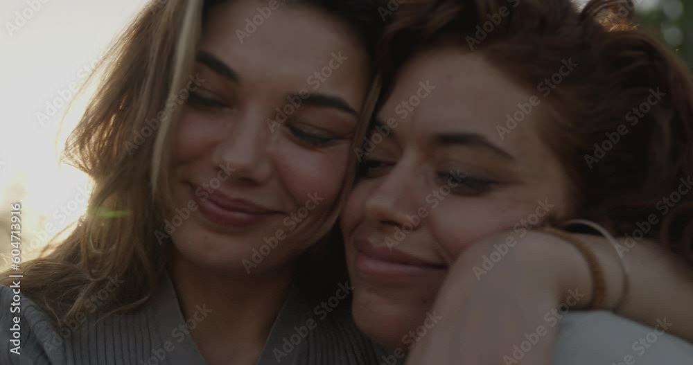Two young women embrace outside Two young women embrace outside