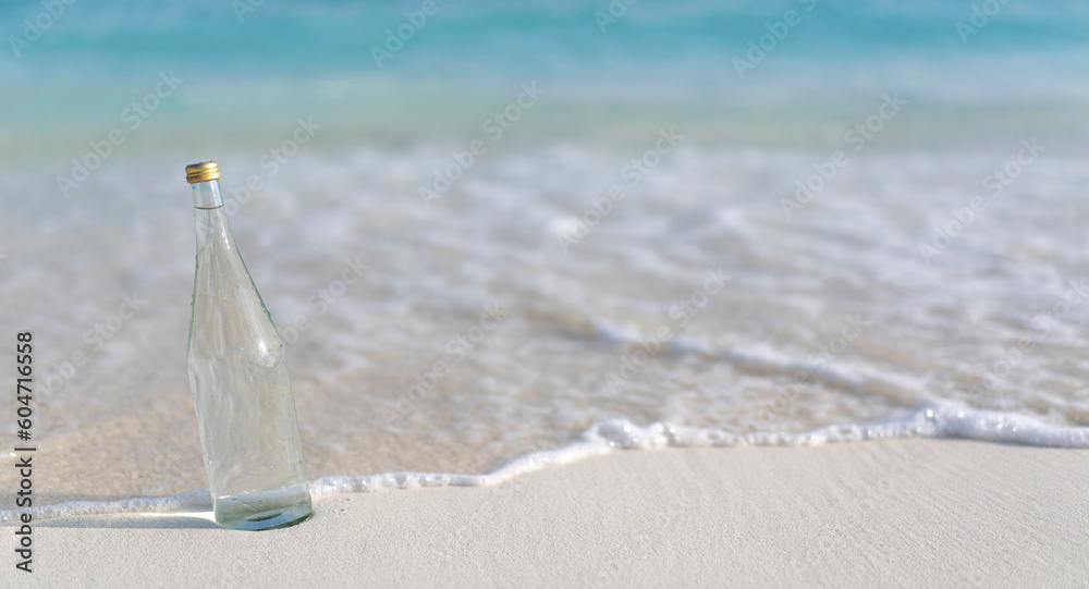 Glass bottle of pure water on the background of ocean