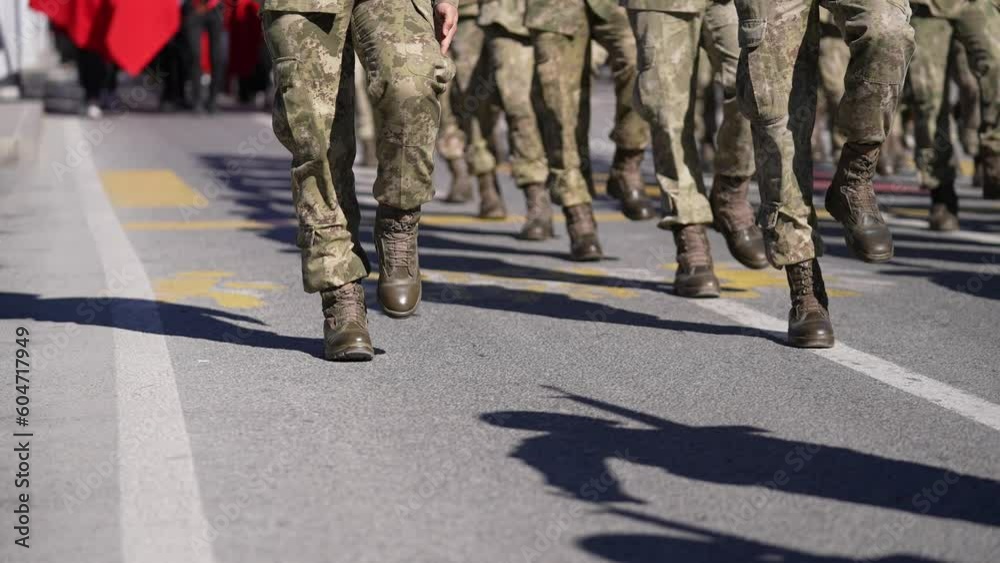 Soldiers marching with military clothes in cadence at an army parade on road Soldiers marching with military clothes in cadence at an army parade on road