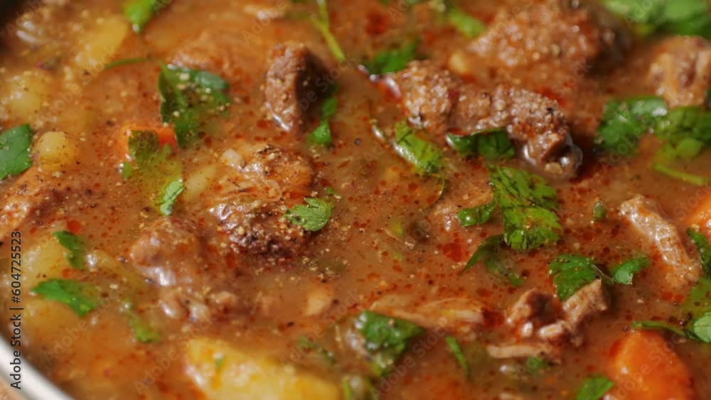 Hungarian goulash soup cooking close-up in pot, chef cook traditional polish or zech soup in restaurant. Hungarian goulash soup cooking close-up in pot, chef cook traditional polish or zech soup in restaurant.