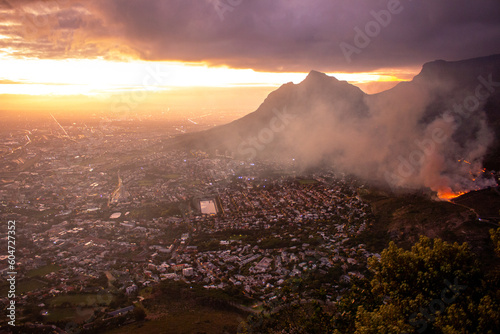 Cape Town, South Africa, 29th March 2023. A controlled burn at the foot of Table Mountain at sunrise, the view from Lions Head.