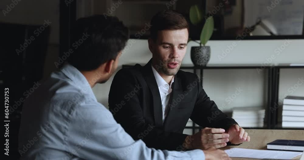 Two male employees consider joint task sitting at modern office, hold discussion, share creative ideas, plan strategy, search solution engaged in teamwork, manager makes business proposal to client Two male employees consider joint task sitting at modern office, hold discussion, share creative ideas, plan strategy, search solution engaged in teamwork, manager makes business proposal to client