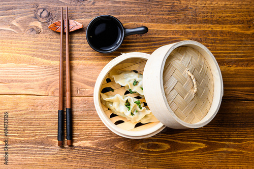 Chinese snacks. chinese steamed dumpling. Chinese Traditional cuisine concept. in wooden steamer soy sauce and chopsticks top view space for text