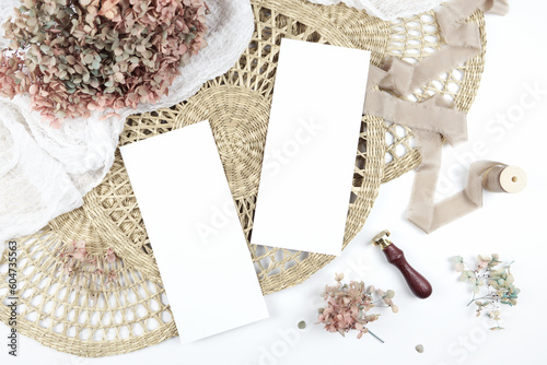 Double sided 4x9 menu card. Wedding stationery suite mock-up styled with boho decor, dried hydrangea flowers bouquet, rattan lace mats, vintage wax seal, and silk ribbon. photo