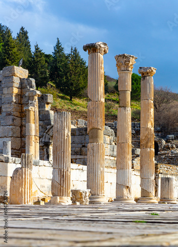View of remained columns of ancient State Agora in Ephesus on background of ruins of small Odeon in winter day, Izmir province, Turkey.. photo
