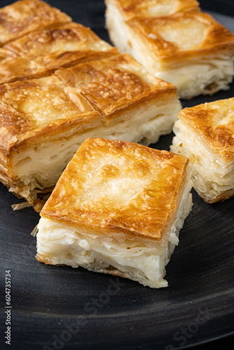 Delicious Turkish food Tray pastry with cheese, on black wooden table background
