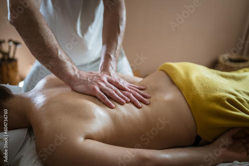 unknown woman enjoy back massage at beauty spa male therapist