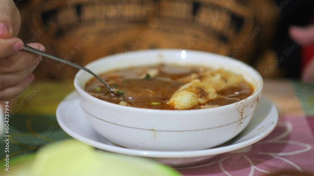 Eating Coto Makassar Traditonal Beef Soup. Coto Makassar, traditional food from Makassar, South Sulawesi. made from beef offal mixed with beef, seasoned with specially formulated spices. Eating Coto Makassar Traditonal Beef Soup. Coto Makassar, traditional food from Makassar, South Sulawesi. made from beef offal mixed with beef, seasoned with specially formulated spices.