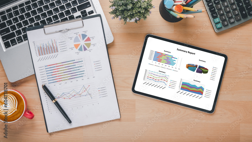 Obraz premium Tablet with charts and reports on office desk workplace. Top view flat lay.