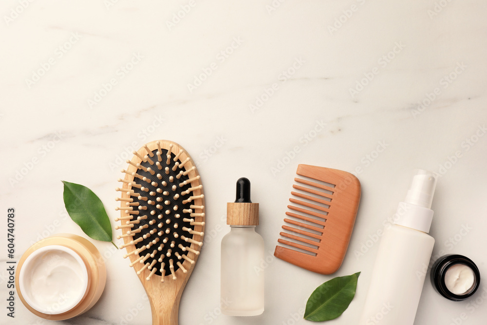 Flat lay composition with wooden hair brush and comb on white marble table, space for text - obrazy, fototapety, plakaty 