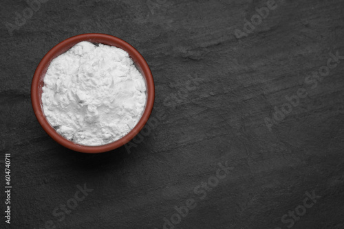 Fotografía Bowl of natural starch on black table, top view. Space for text