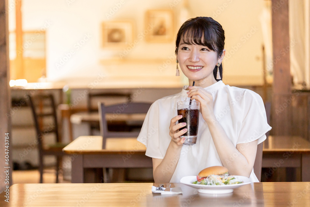 お昼休みにレストラン・カフェでランチ・食事をするアジア人のビジネスウーマン
