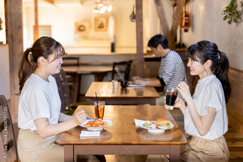カフェ・レストラン・飲食店でランチをしながらおしゃべりする若いアジア人女性 