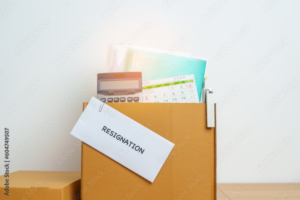 Resignation, Layoff, Unemployment, Dismiss, Job quit, Jobless and Farewell concept. letter of Resign contract with documents cardboard box at office Resignation, Layoff, Unemployment, Dismiss, Job quit, Jobless and Farewell concept. letter of Resign contract with documents cardboard box at office
