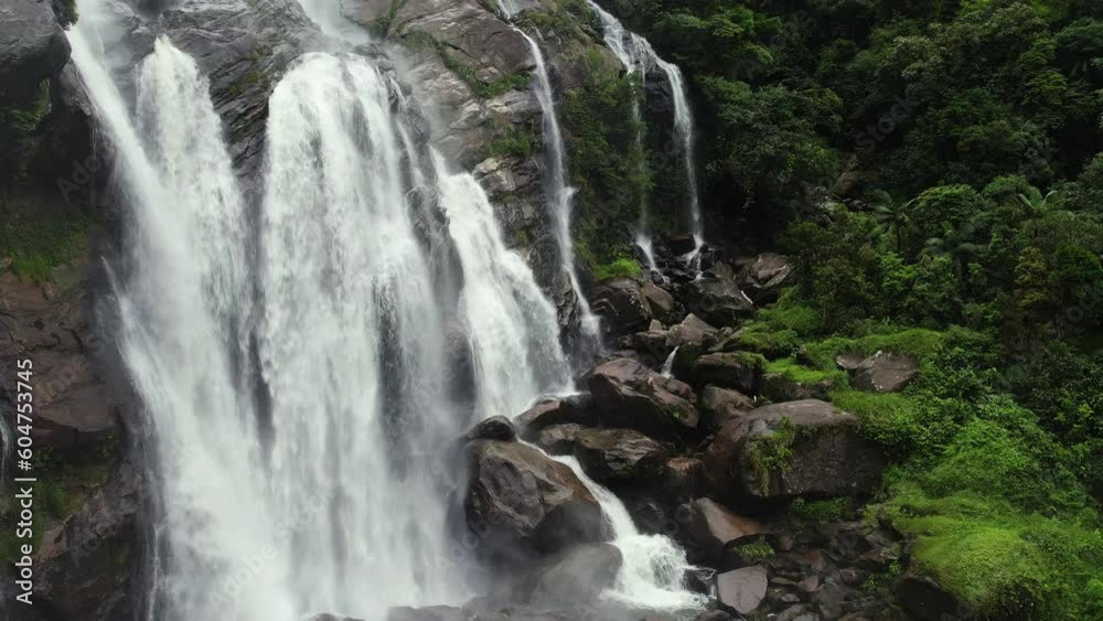 Aerial view in front of a flowing waterfall in cloudy Barro da Sahy, Brazil - static, drone shot Aerial view in front of a flowing waterfall in cloudy Barro da Sahy, Brazil - static, drone shot