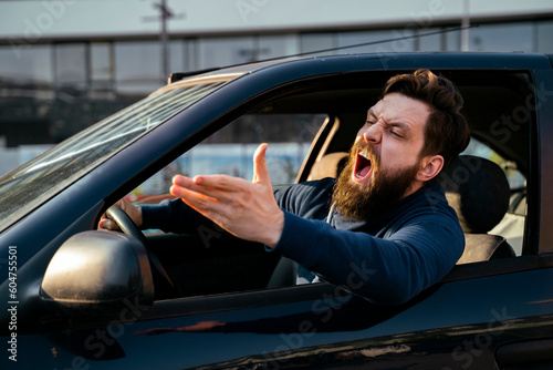 Bearded young man road raging , yelling from the car closeup shot