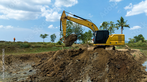 excavating soil into a dump truck to build a pond for store water for use in the dry season for agriculture photo