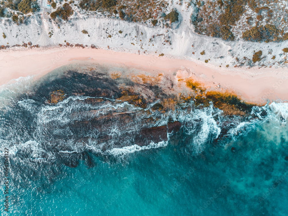 Aerial view of pink sandy beach with waves. Sunny day in summer with transparent tropical blue water. Summer seascape beautiful waves, blue sea water on a sunny day. Top view from drone. Sea aerial