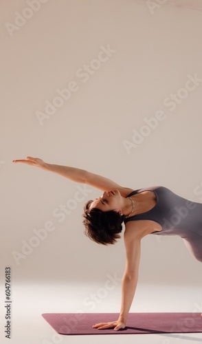 Young pregnant woman doing yoga exercises and meditating at studio. Health care, mindfulness and wellness concept.
